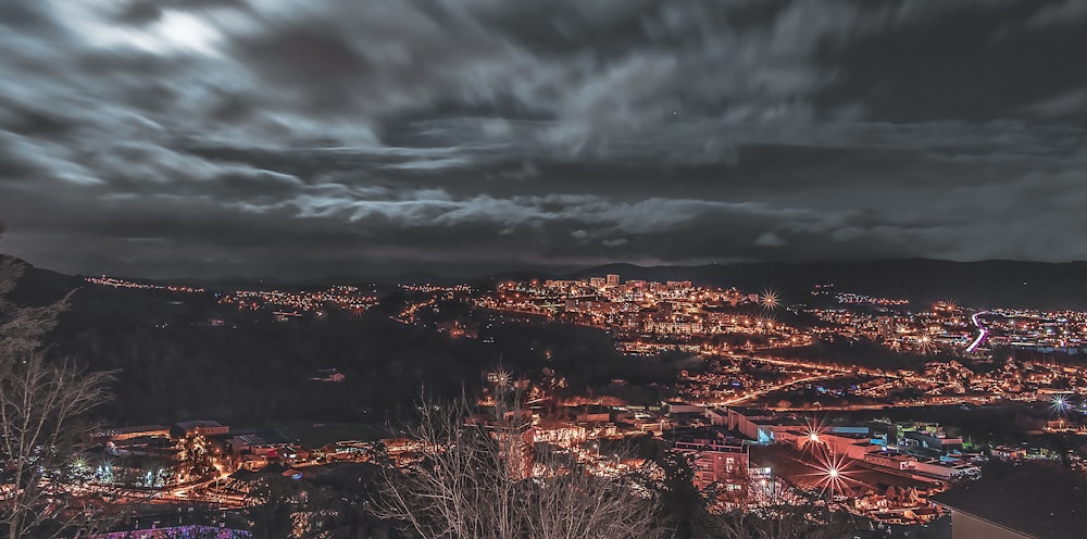 aerial photography of lighted buildings under cloudy sky at night