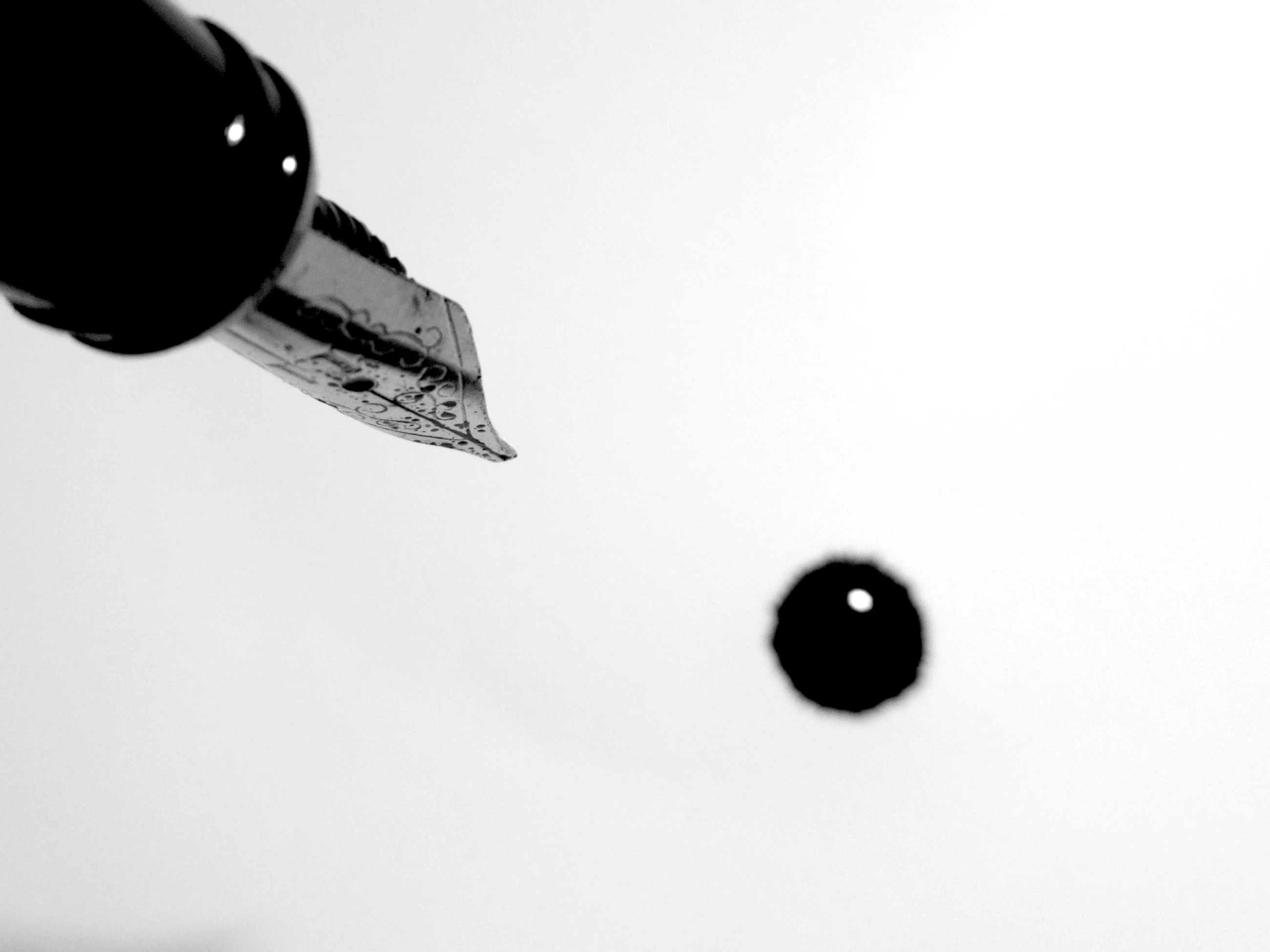 A fountain pen releasing a drop of ink