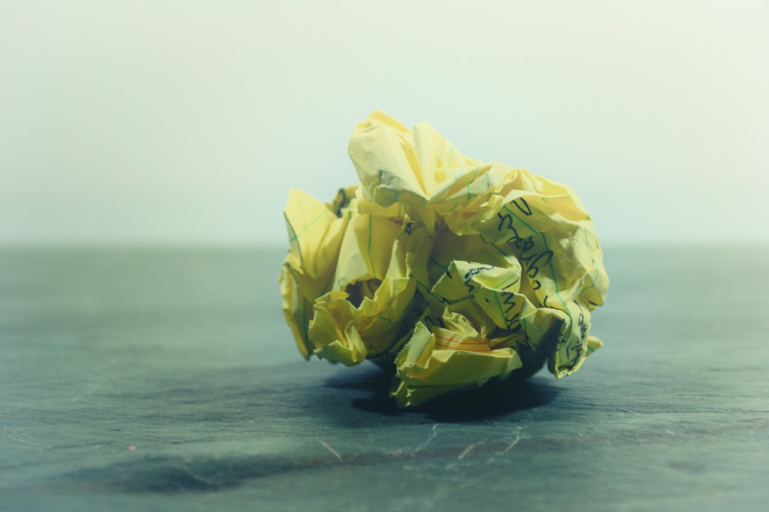 crumpled yellow ruled paper on gray panel, Balled up paper