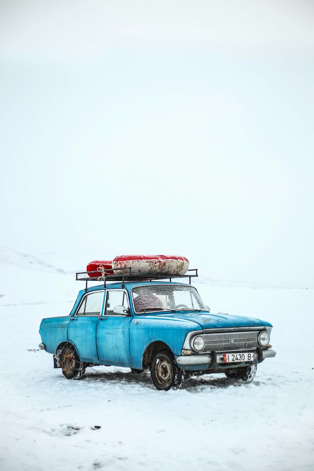 sedan azul no chão de neve