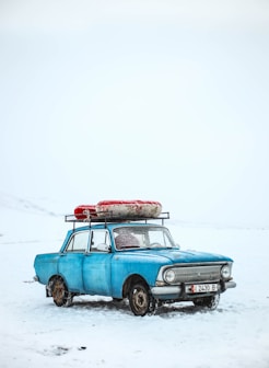 blue sedan on snow ground