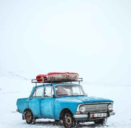 blue sedan on snow ground