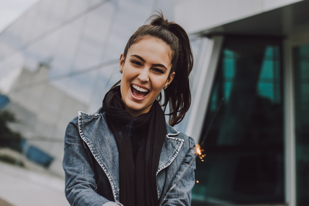 Femme portant une veste en jean grise et une écharpe noire