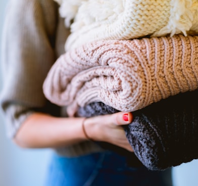 person holding knitted textiles