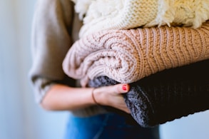 person holding knitted textiles