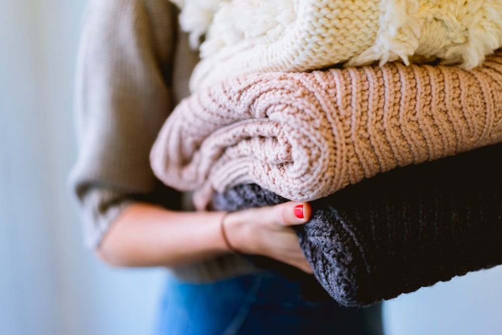 Person, die gestrickte Textilien in der Hand hält