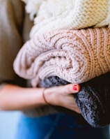 person holding knitted textiles