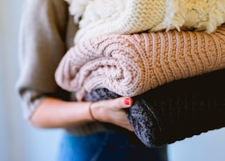 person holding knitted textiles