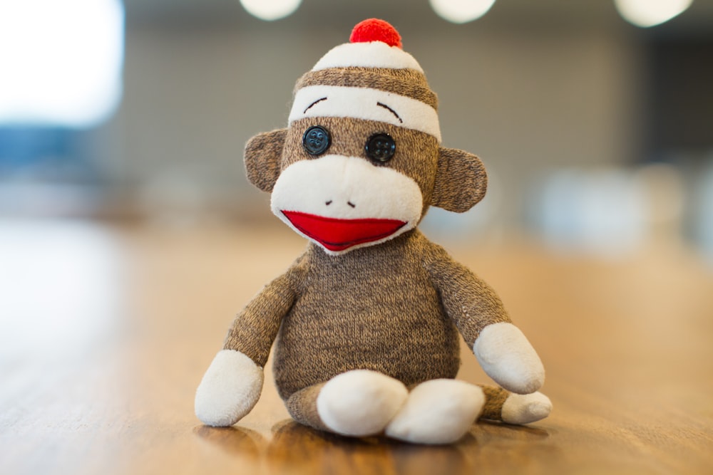 Sock Monkey plush toy on brown panel