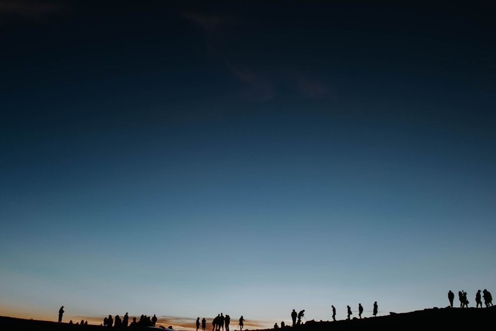 silhouette of people standing in cliff