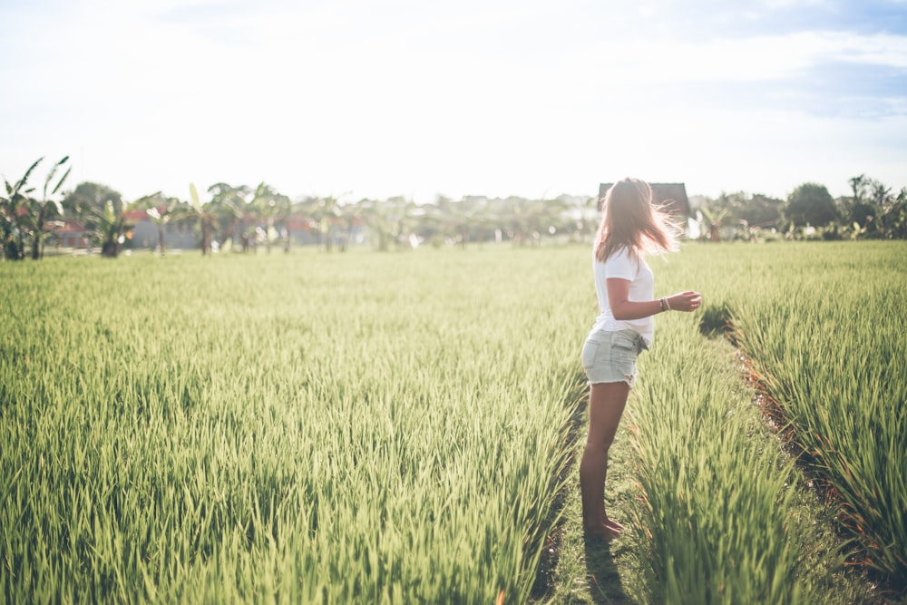 Mulher Stand em campos de arroz verde