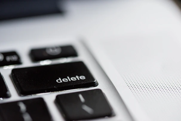 A close-up of a hand deleting a file named install.php on a computer.