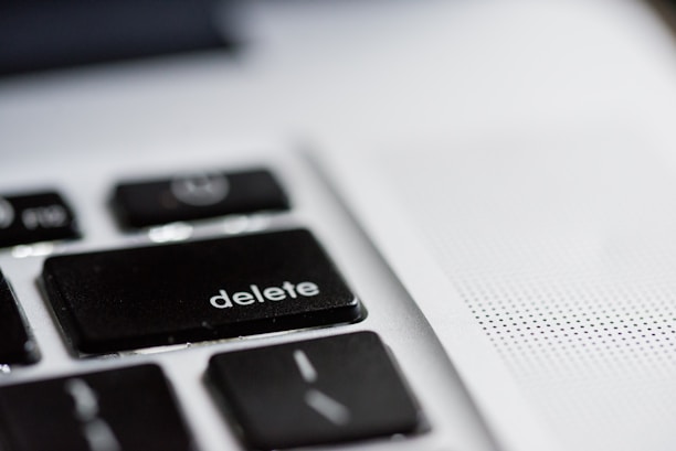 A close-up view of a computer keyboard, focusing on the black 'delete' key, with part of a speaker or vent area visible on the right side.