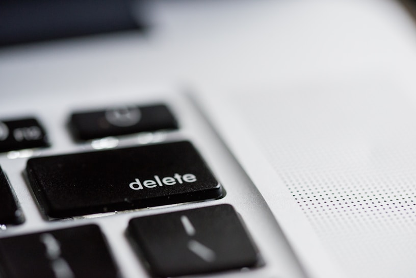 A close-up view of a computer keyboard, focusing on the black 'delete' key, with part of a speaker or vent area visible on the right side.