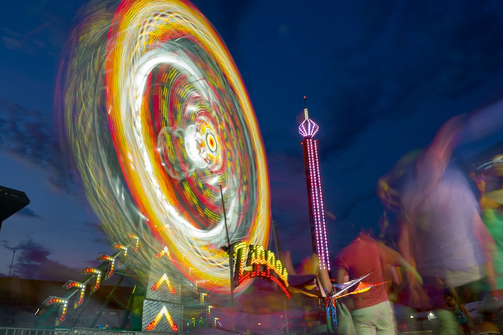 foto time-lapse della ruota panoramica illuminata al parco durante la notte