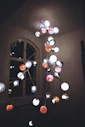 An electrician installing a chandelier in a modern living room.