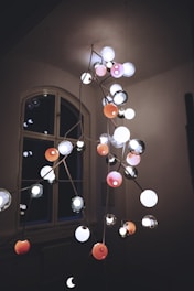 An electrician installing a chandelier in a modern living room.