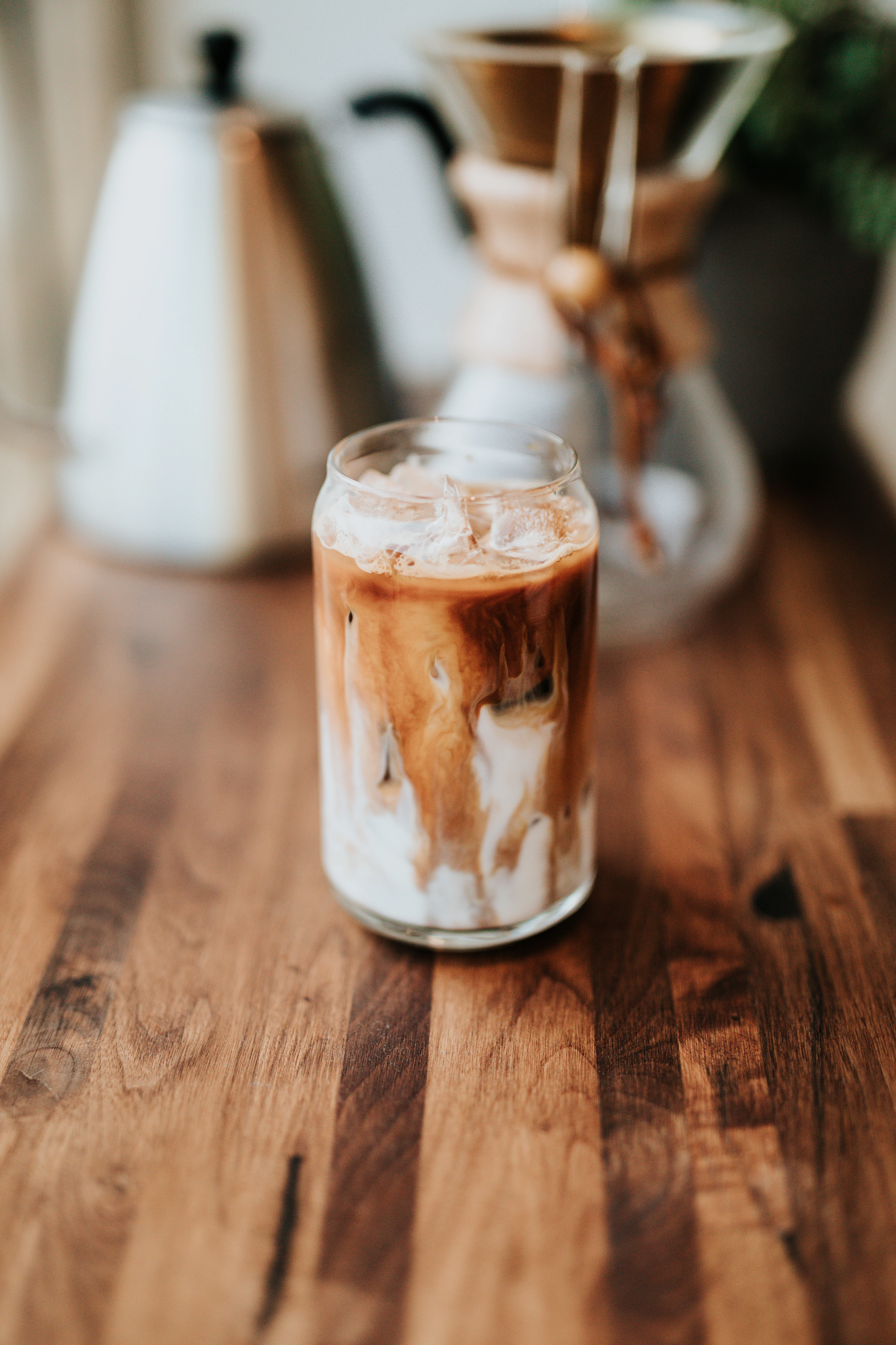 A tall glass of iced coffee on a table