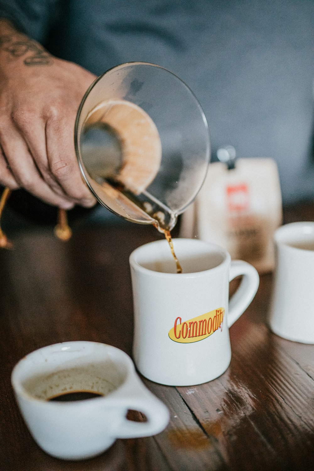 person pouring liquid in white ceramic mug