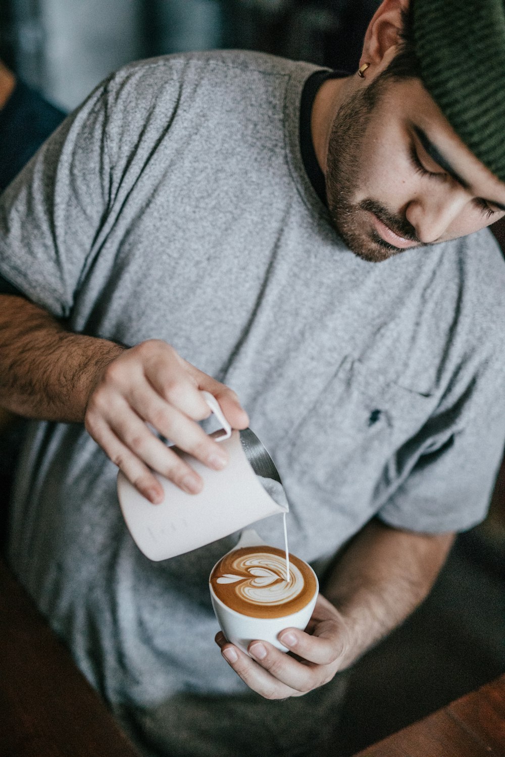 hombre con camiseta gris de cuello redondo haciendo capuchino