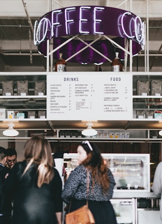 group of people standing in front of food stall counter