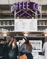 group of people standing in front of food stall counter