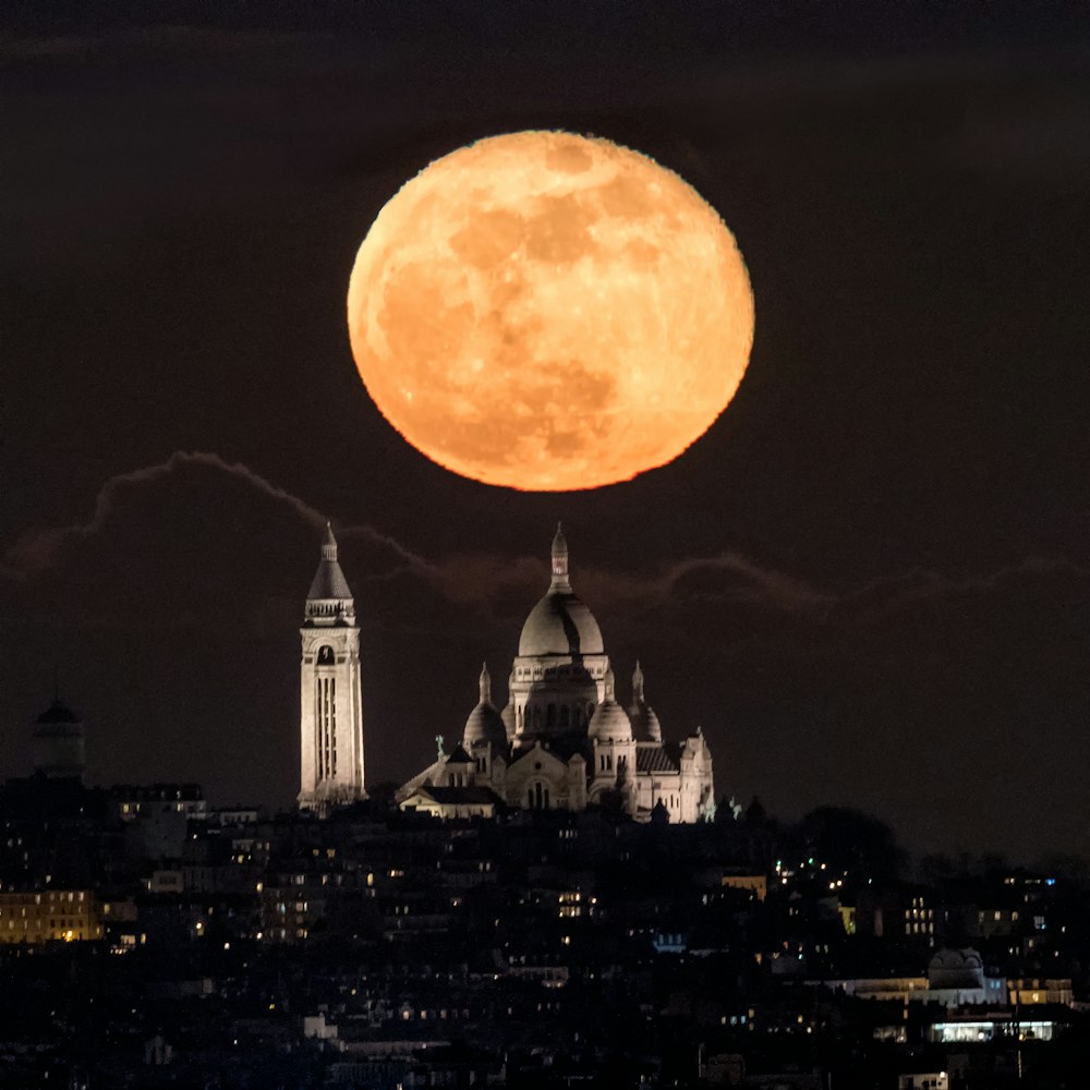 white mosque near city under full moon sky