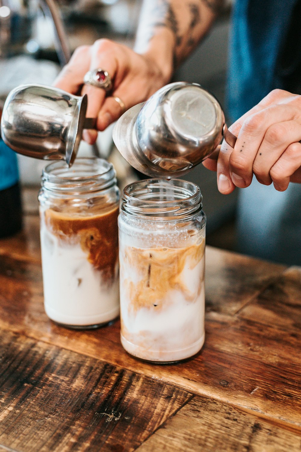 person pouring liquid on drinking glasses