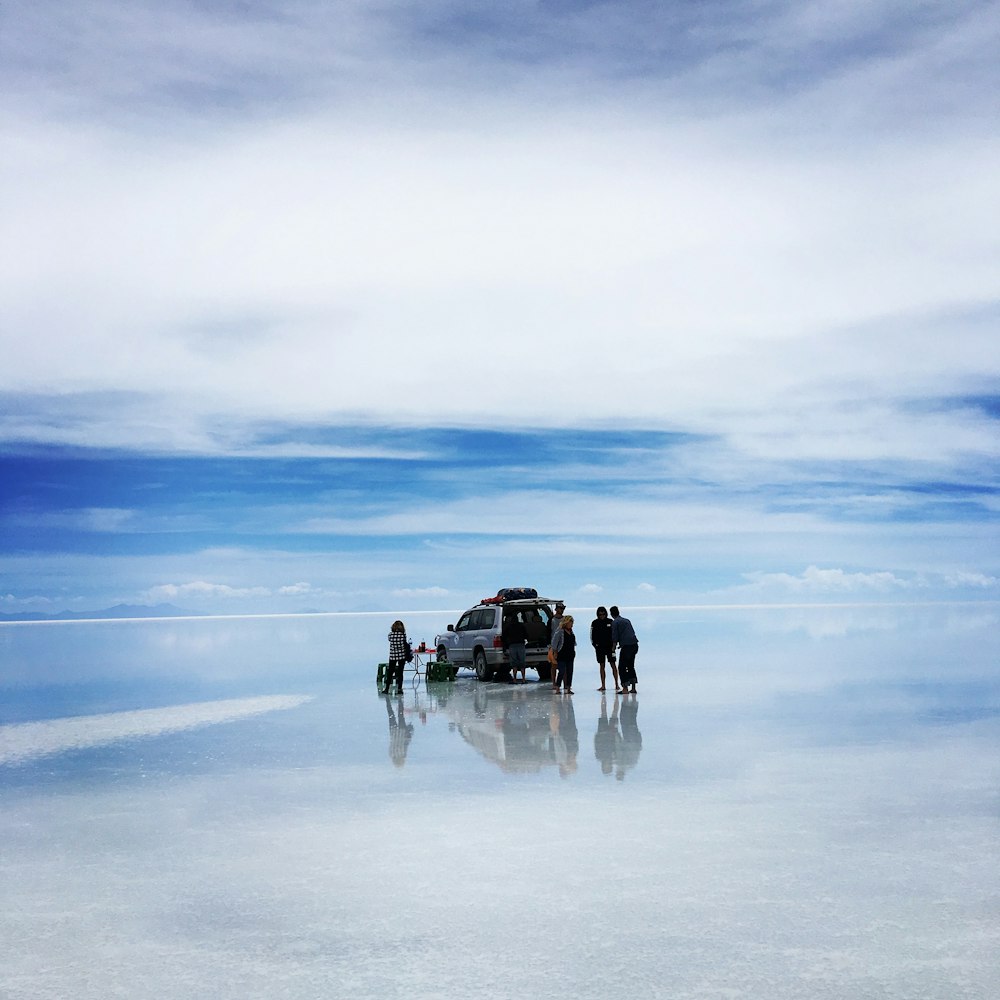 people standing near silver SUV