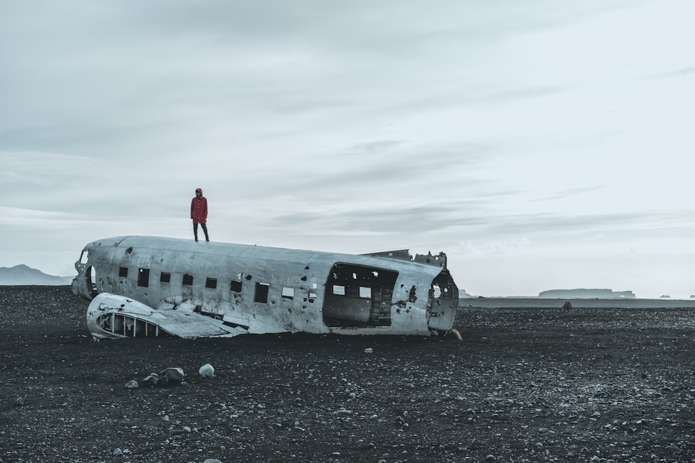 Persona parada en un avión destrozado
