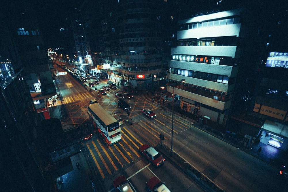 夜間の道路を走る白いバスの写真