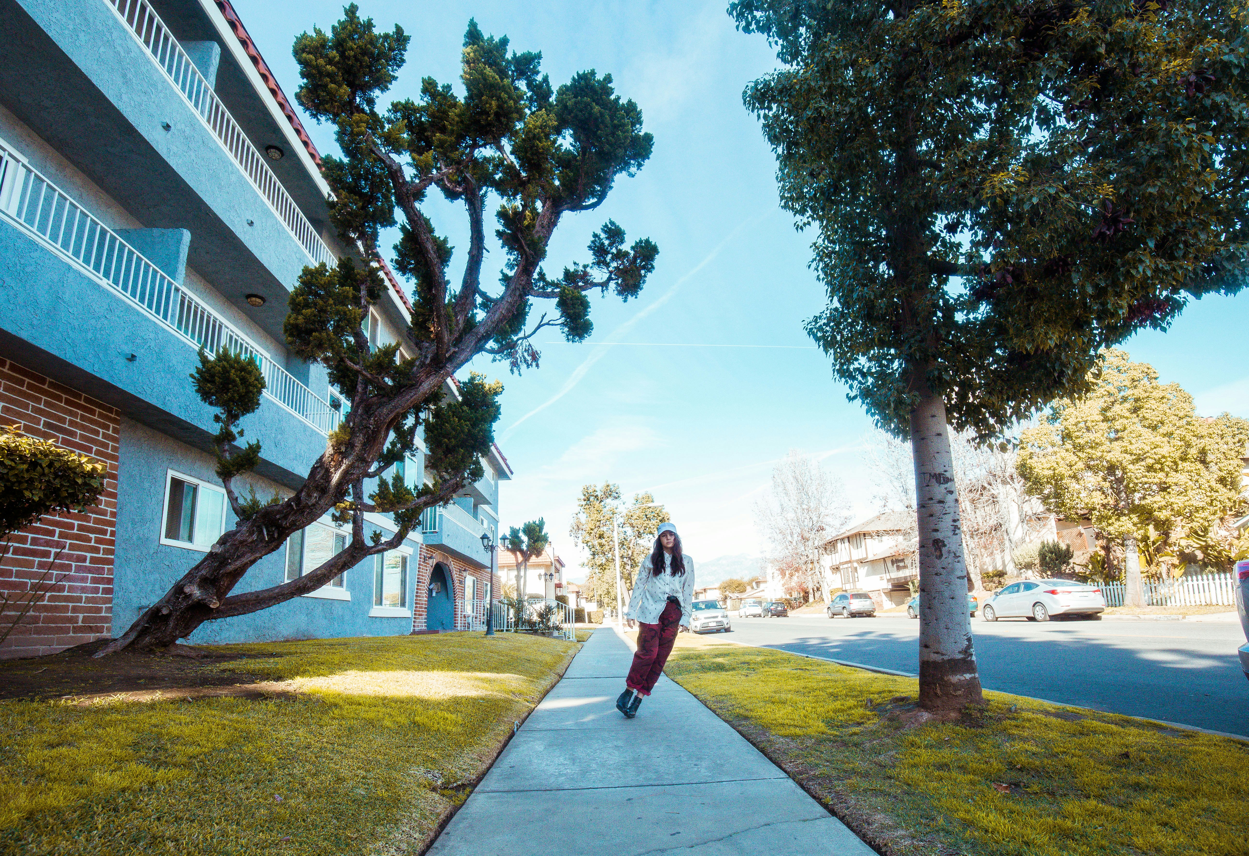 woman standing in front of building between trees