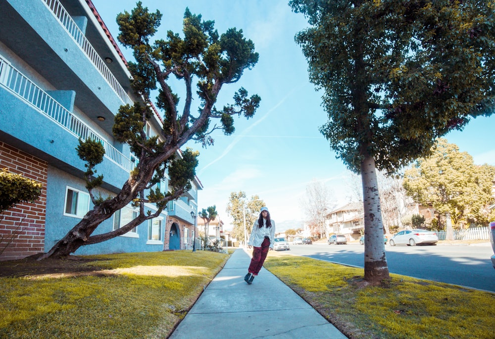 woman standing in front of building between trees