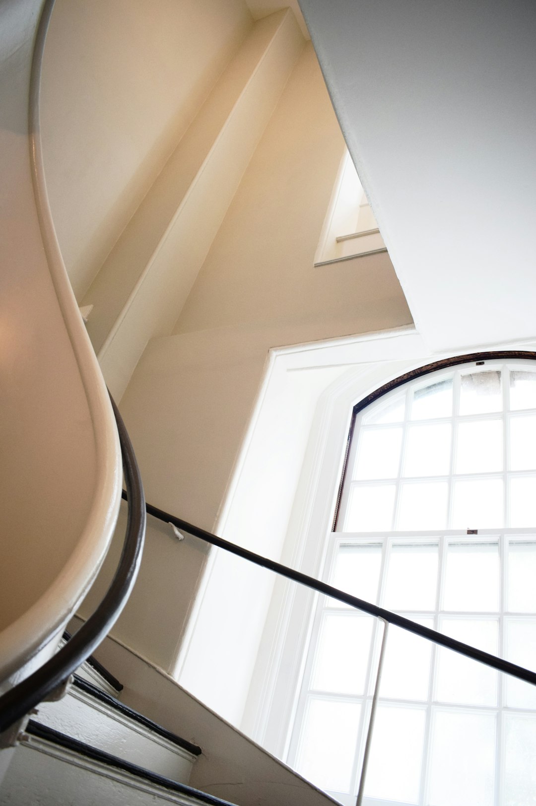 black metal spiral staircase near white wall