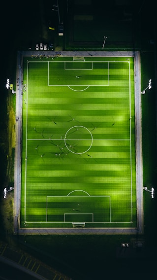A sleek, aerial view of the pro-grade football turf with crisp lines under evening lights.