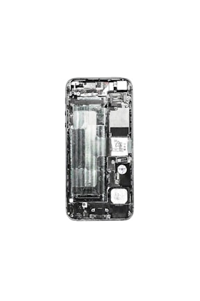 A disassembled view of a smartphone displaying its internal components such as the circuit board, battery compartment, and various connectors. The phone case is removed, exposing the intricate layout of electronic parts.