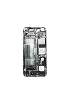 A disassembled view of a smartphone displaying its internal components such as the circuit board, battery compartment, and various connectors. The phone case is removed, exposing the intricate layout of electronic parts.