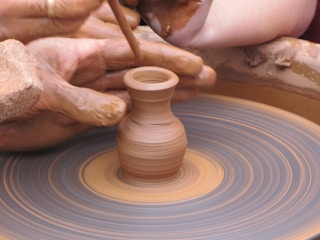 Close-up of a craftsman crafting handmade pottery on a spinning wheel.
