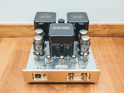 Vintage-style guitar amplifier with glowing tubes on a wooden workbench.