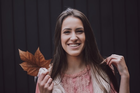 A cheerful cartoon girl holding a wooden sign that reads 'yo soy belab' surrounded by autumn leaves.