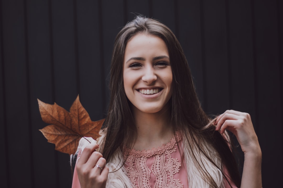 woman holding brown leaf