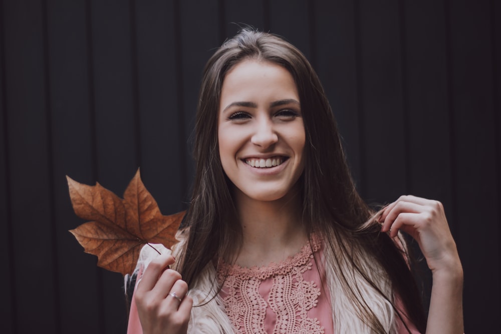 Femme tenant une feuille brune