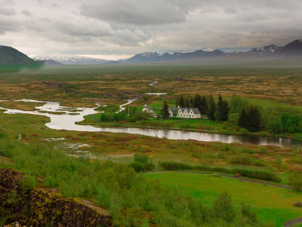 A serene mountain landscape with a winding river and traditional Balkan houses nestled in the valley