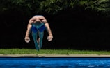 Young Congolese swimmer diving into a clear blue pool during a competition.