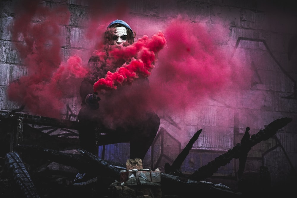 man with pink smoke digital wallpaper
