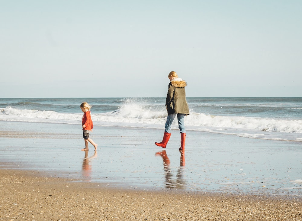 donna e bambino in piedi sulla riva del mare