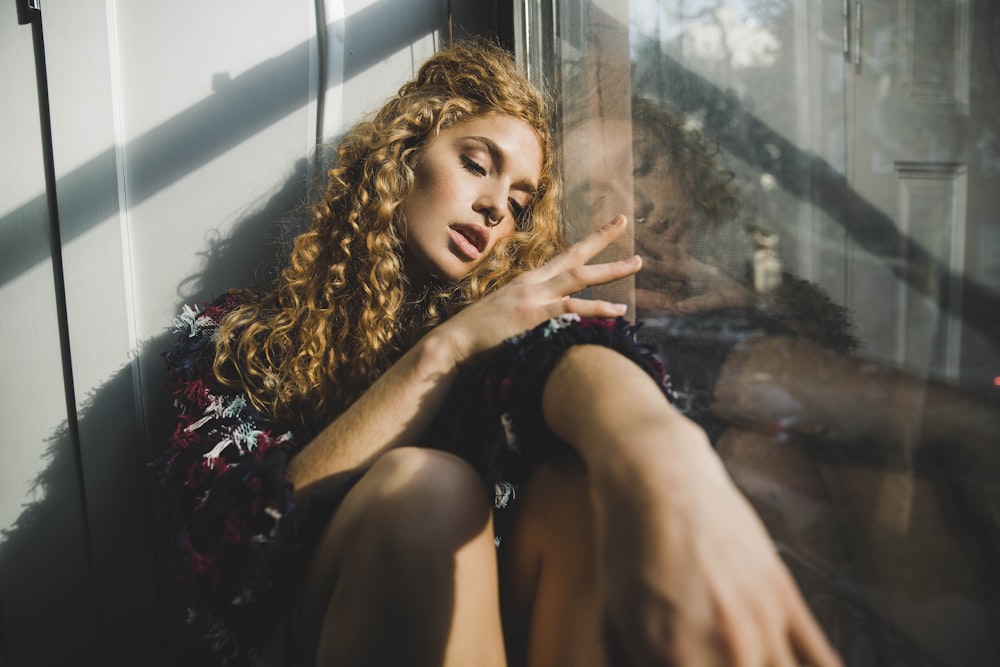 Siège de femme à côté d’un mur de verre