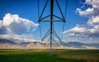 brown mountains and green grass field under white clouds during daytime