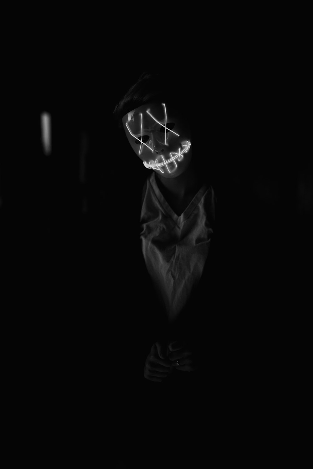uma foto em preto e branco de uma pessoa usando uma máscara