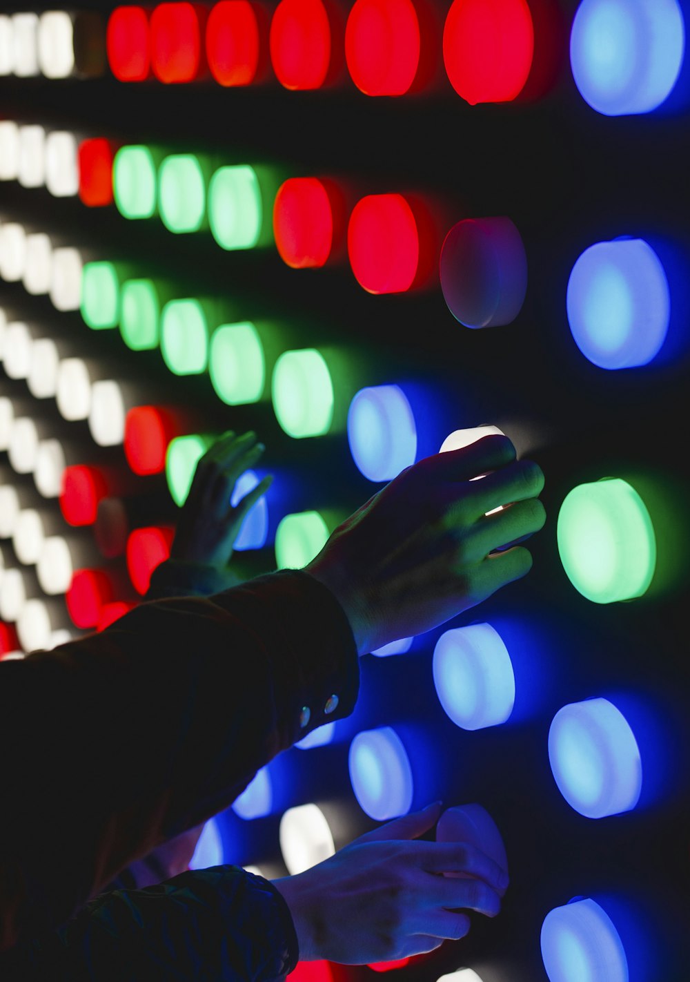 pessoas segurando luzes LED de cores variadas
